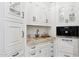 Butler's pantry with white cabinets, granite countertops, and a coffee maker at 9926 E Kemper Way, Scottsdale, AZ 85255