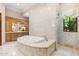 Elegant bathroom with a large soaking tub, double vanities, and decorative tile at 9926 E Kemper Way, Scottsdale, AZ 85255