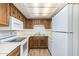 Kitchen with wood cabinets, white appliances, and flooring at 3002 N 70Th St # 239, Scottsdale, AZ 85251