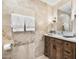 Elegant bathroom with wood vanity, beige stone tile, and large mirror at 7117 E Rancho Vista Dr # 4011, Scottsdale, AZ 85251