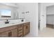 Double vanity bathroom with modern finishes and a walk-in closet at 37535 W Padilla St, Maricopa, AZ 85138