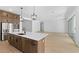Open concept kitchen with island, stainless steel appliances, and light wood cabinets at 37535 W Padilla St, Maricopa, AZ 85138