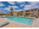 Community pool with surrounding patio furniture and building in the background at 8055 E Thomas Rd # E117, Scottsdale, AZ 85251