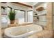 Relaxing bathroom with a luxurious jetted tub and glass shelving at 1020 E Caroline Ln, Tempe, AZ 85284