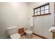 Simple bathroom with toilet, bidet, and a small window for ventilation at 1020 E Caroline Ln, Tempe, AZ 85284