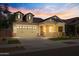 Two-story home with dormer windows, a large front porch, and warm lighting at 19749 S 231 St. Way, Queen Creek, AZ 85142