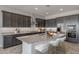 Spacious kitchen with dark cabinetry, granite island, and stainless steel appliances at 19749 S 231 St. Way, Queen Creek, AZ 85142