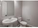 Clean and simple bathroom with pedestal sink and toilet at 19749 S 231 St. Way, Queen Creek, AZ 85142