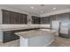 Modern kitchen with dark cabinets, granite countertops, and a large island at 19749 S 231 St. Way, Queen Creek, AZ 85142