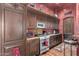 Kitchen with dark wood cabinets, stainless steel appliances, and wood floors at 3831 E Huber St, Mesa, AZ 85205