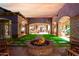 Landscaped courtyard with a fire pit, stone accents, and seating at 3831 E Huber St, Mesa, AZ 85205