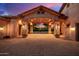 Driveway entrance with stone archway and landscape lighting at dusk at 3831 E Huber St, Mesa, AZ 85205