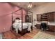 Bedroom with a canopy bed, built-in desk, and hardwood floors at 3831 E Huber St, Mesa, AZ 85205