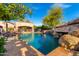 Inviting swimming pool with a rock waterfall feature at 3831 E Huber St, Mesa, AZ 85205