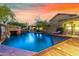 Expansive pool with rock waterfall feature and lounge chairs at dusk at 3831 E Huber St, Mesa, AZ 85205