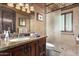 Bathroom with granite vanity, a shower with glass enclosure, and wood cabinets at 3831 E Huber St, Mesa, AZ 85205
