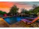 Resort style pool with lounge chairs and rock waterfall feature at 3831 E Huber St, Mesa, AZ 85205