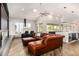 Open living room with a modern fireplace, large windows, and a brown leather sectional sofa at 1920 E Schooner Ct, Gilbert, AZ 85234