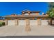 Front view of a two-story stucco building with four attached garages at 11500 E Cochise Dr # 2011, Scottsdale, AZ 85259