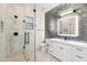 Modern bathroom with a glass shower, white vanity, and dark tile at 8509 S 10Th Ln # 23, Phoenix, AZ 85041