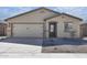One-story house with a beige exterior, a two-car garage, and a gravel landscaping at 24636 W St Catherine Ave, Buckeye, AZ 85326