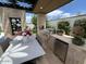 Outdoor kitchen with built-in grill, refrigerator, and seating area at 5755 S Joshua Tree Ln, Gilbert, AZ 85298
