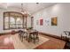 Sunlit dining room featuring hardwood floors, a wooden table and modern artwork at 6215 E Turquoise Ave, Paradise Valley, AZ 85253