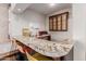 L-shaped granite wet bar with seating and custom cabinetry at 6215 E Turquoise Ave, Paradise Valley, AZ 85253