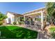 Landscaped backyard with a pergola-covered patio and lush lawn at 20371 E Calle De Flores --, Queen Creek, AZ 85142