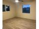 Bright bedroom with wood-look floors and two windows at 2303 W Marshall Ave, Phoenix, AZ 85015