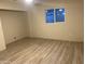 Bright bedroom with wood-look floors and large window at 2303 W Marshall Ave, Phoenix, AZ 85015