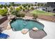 Inviting pool with waterfall feature, surrounded by rocks and lush landscaping at 16612 N 151St Ln, Surprise, AZ 85374