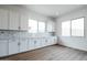 White kitchen cabinets and quartz countertops, geometric backsplash. Wood-look tile floor at 10010 S 37Th Ave, Laveen, AZ 85339