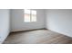 Simple bedroom with wood-look floors and a window at 10010 S 37Th Ave, Laveen, AZ 85339