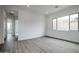 Bright bedroom with wood-look tile floors and access to hallway at 10010 S 37Th Ave, Laveen, AZ 85339