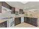 Kitchen with an island, white appliances, and dark brown cabinets at 8125 E Billings St, Mesa, AZ 85207