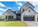 Two-story farmhouse style home with gray siding, brick accents, and a black garage door at 4007 E Montecito Ave, Phoenix, AZ 85018