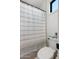 Clean bathroom with a toilet, shower, and striped shower curtain at 4007 E Montecito Ave, Phoenix, AZ 85018