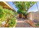 Landscaped backyard with tiled patio and wooden gate at 4525 N 66Th St # 70, Scottsdale, AZ 85251