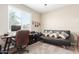 Bright home office with a desk, comfortable couch, and ample natural light at 20051 N Herbert Ave, Maricopa, AZ 85138