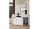Convenient wet bar with granite countertop, wine cooler, and white cabinets at 9975 E Broken Spur Dr, Scottsdale, AZ 85262