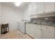 Laundry room with white cabinets and granite countertops at 9975 E Broken Spur Dr, Scottsdale, AZ 85262