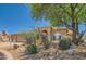 Tan house with a two-car garage and desert landscaping at 9768 E Balancing Rock Rd, Scottsdale, AZ 85262