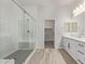 Modern bathroom with a walk-in shower, grey hexagon tile, and white cabinets at 1973 W Brooke Ln, Queen Creek, AZ 85144