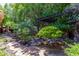 Landscaped backyard with stone pathway, pergola, and lush greenery at 94 Biltmore Est, Phoenix, AZ 85016