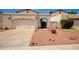 Front view of a tan house with a two-car garage and a landscaped yard at 4760 W Wahalla Ln, Glendale, AZ 85308