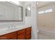 Clean bathroom with wood vanity and bathtub shower combo at 4760 W Wahalla Ln, Glendale, AZ 85308
