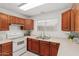 Kitchen features wood cabinets, tile floors, and white appliances at 4760 W Wahalla Ln, Glendale, AZ 85308