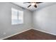 Simple bedroom featuring wood-look floors and a window with blinds at 5557 W Buckskin Trl, Phoenix, AZ 85083
