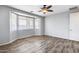 Bedroom featuring wood-look floors and large window with blinds at 5557 W Buckskin Trl, Phoenix, AZ 85083